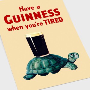 Pode incluir: Um cartaz vintage que anuncia a cerveja Guinness com o texto "Have a GUINNESS when you're TIRED". Uma tartaruga de desenho animado est&aacute; carregando um copo de Guinness nas costas.