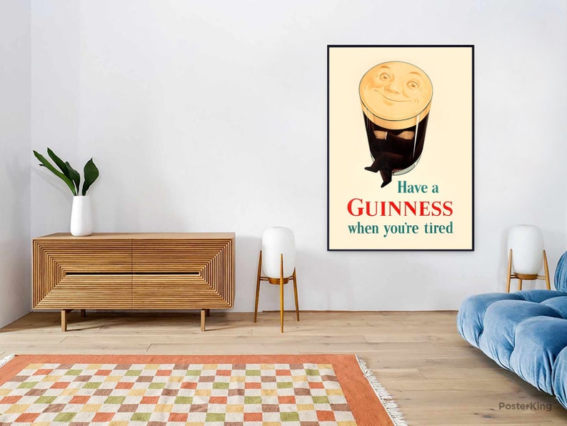 May include: A framed Guinness advertisement poster. The poster features a smiling pint of Guinness with arms and legs, with the text "Have a Guinness when you're tired" in red and green.