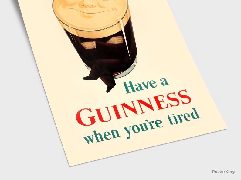 May include: Vintage Guinness advertisement poster. The image features a pint of Guinness with a smiling face and the text "Have a Guinness when you're tired" in red and teal. The poster has a cream-colored background.