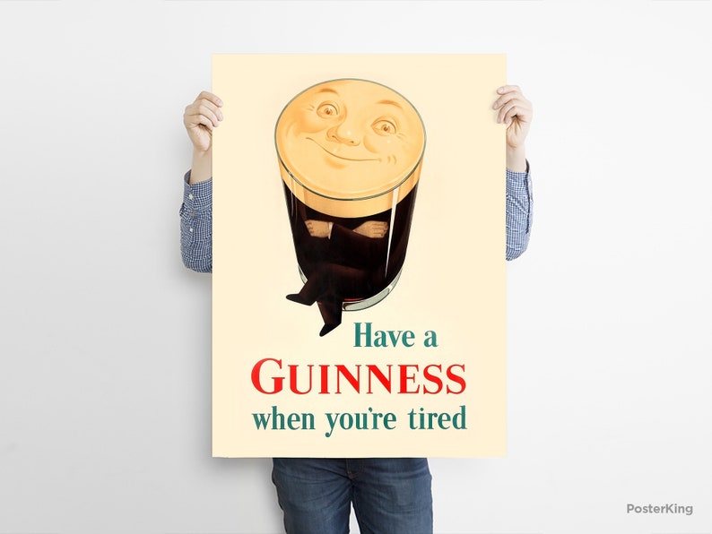 May include: Vintage Guinness advertisement poster. The poster features a smiling pint of Guinness with arms crossed, and legs crossed. The text reads "Have a Guinness when you're tired" in red and green.