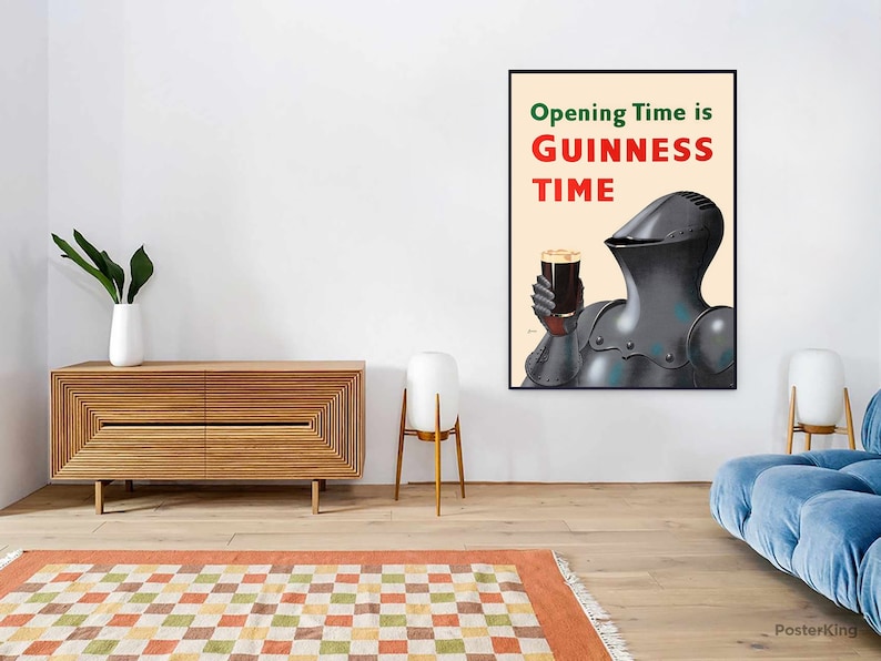 May include: A framed poster with the text "Opening Time is GUINNESS TIME" in red and green. The image features a knight in armor holding a pint of dark beer. The poster is displayed on a white wall in a room with modern furniture.