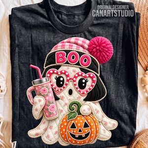 May include: A dark gray t-shirt featuring a quilted-style graphic of a ghost wearing a pink and white checkered beanie with a pom-pom, heart-shaped glasses, and holding a floral tumbler and an orange jack-o'-lantern with the text BOO.