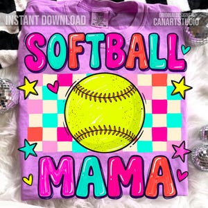 May include: A lilac-colored t-shirt with the words "SOFTBALL MAMA" in a colorful, bubble-letter style. A yellow softball is centered on the shirt, with a checkered pattern in the background. The shirt also features star and heart graphics.