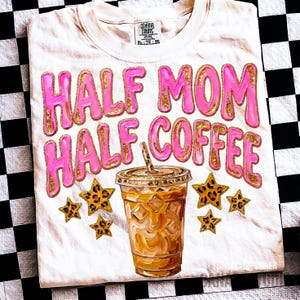 May include: White t-shirt with the text "HALF MOM HALF COFFEE" in pink bubble letters with gold glitter accents. An iced coffee cup and leopard print stars are also featured in the design.
