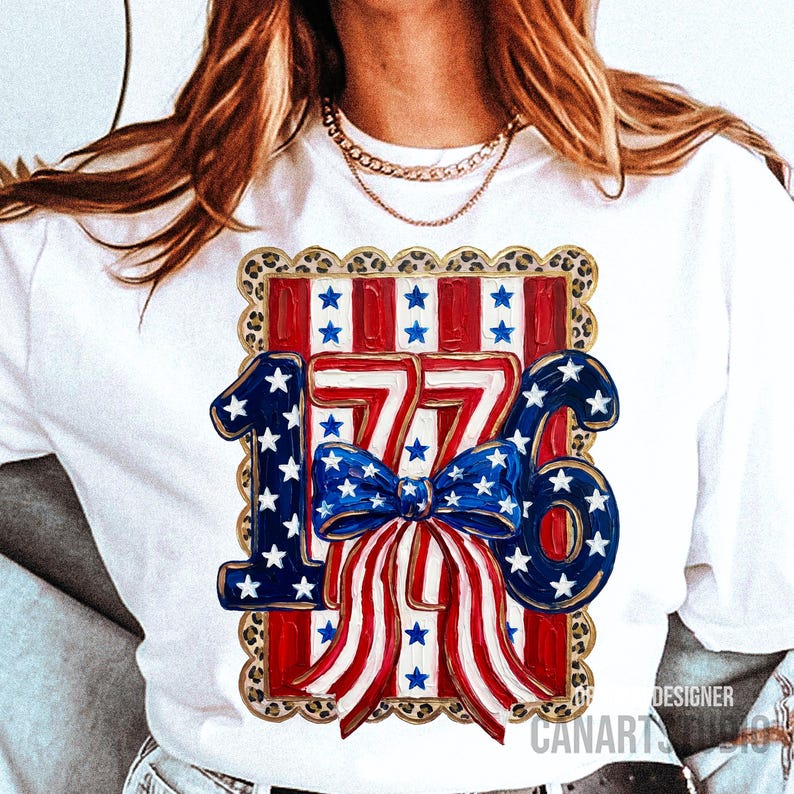 May include: White t-shirt with a patriotic design featuring the number "1776" in red, white, and blue. The design includes a bow and stars, set against a leopard print border. The shirt is a casual style.