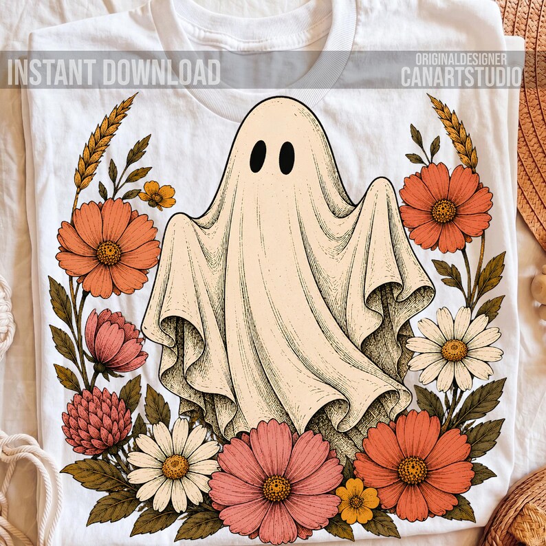 May include: A white t-shirt featuring a central graphic of a cream-colored ghost with black oval eyes, surrounded by a wreath of orange, pink, and white flowers with green leaves. The text INSTANT DOWNLOAD and CANARTSTUDIO is visible.
