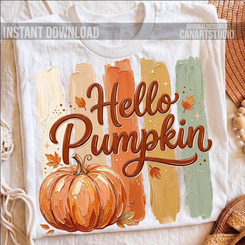 Puede incluir: Camiseta blanca con un dise&ntilde;o de oto&ntilde;o. La camiseta muestra las palabras "Hello Pumpkin" en marr&oacute;n, acompa&ntilde;adas de una ilustraci&oacute;n de calabaza y pinceladas coloridas en tonos naranja, beige y verde. Tambi&eacute;n se ve el texto "Instant Download".