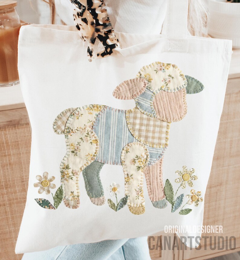 Puede incluir: Bolso tote de color crema con un dise&ntilde;o de cordero de retazos en colores pastel. El cordero est&aacute; rodeado de flores bordadas. El texto "ORIGINAL DESIGNER CANARTSTUDIO" es visible.