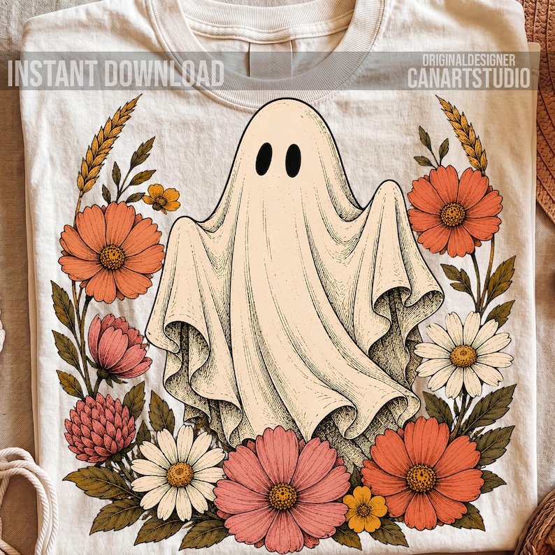 May include: A cream-colored t-shirt featuring a central graphic of a ghost surrounded by a wreath of orange, pink, and white flowers with wheat stalks. The text INSTANT DOWNLOAD and ORIGINALDESIGNER CANARTSTUDIO is printed at the top of the shirt.