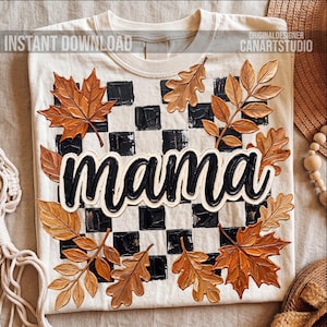 Pode incluir: Camiseta creme com a palavra "mama" em escrita preta, contornada em branco, sobre um padrão xadrez preto e branco. O design é adornado com folhas de outono marrons detalhadas. O texto na camiseta diz "INSTANT DOWNLOAD" e "ORIGINAL DESIGNER CANARTSTUDIO".