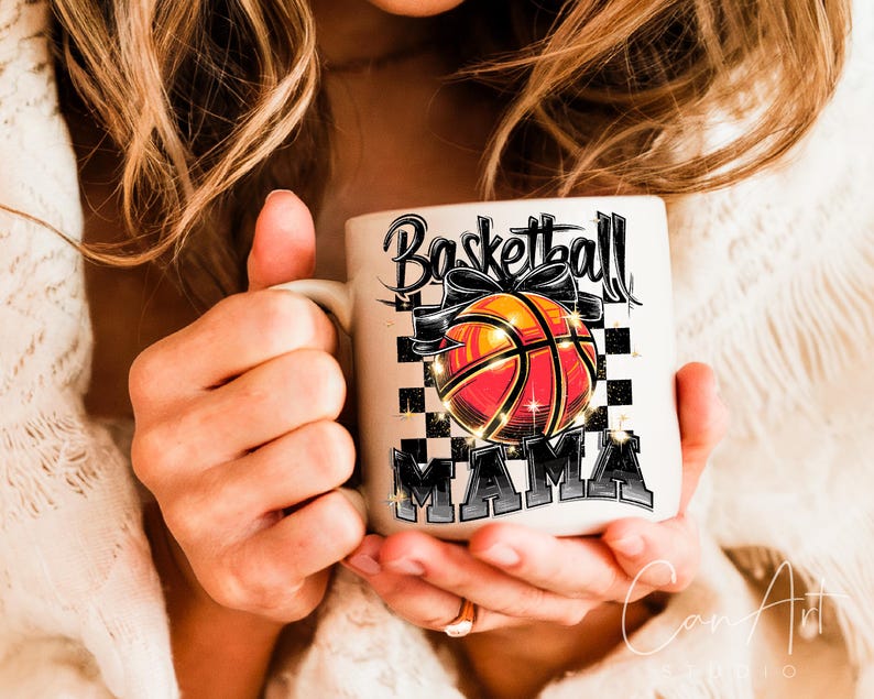 May include: White ceramic mug with a black and white chequered background. The mug has a black and white graphic of a basketball with a bow and the text "Basketball Mama".