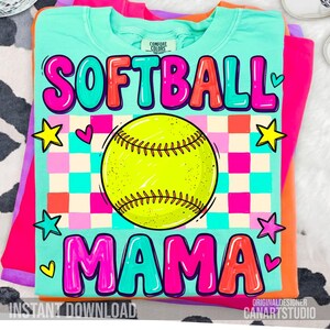May include: A turquoise Comfort Colors t-shirt with the words "SOFTBALL MAMA" in a colorful, bubble letter design. A yellow softball is in the center, with stars and hearts. The shirt is part of a stack of other colorful shirts.