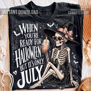 Puede incluir: Camiseta negra con un esqueleto con sombrero de bruja y gafas de sol, sosteniendo una bebida boba. El texto dice: "Cuando estás listo para Halloween pero solo es julio". También se muestran murciélagos, estrellas y una luna creciente.