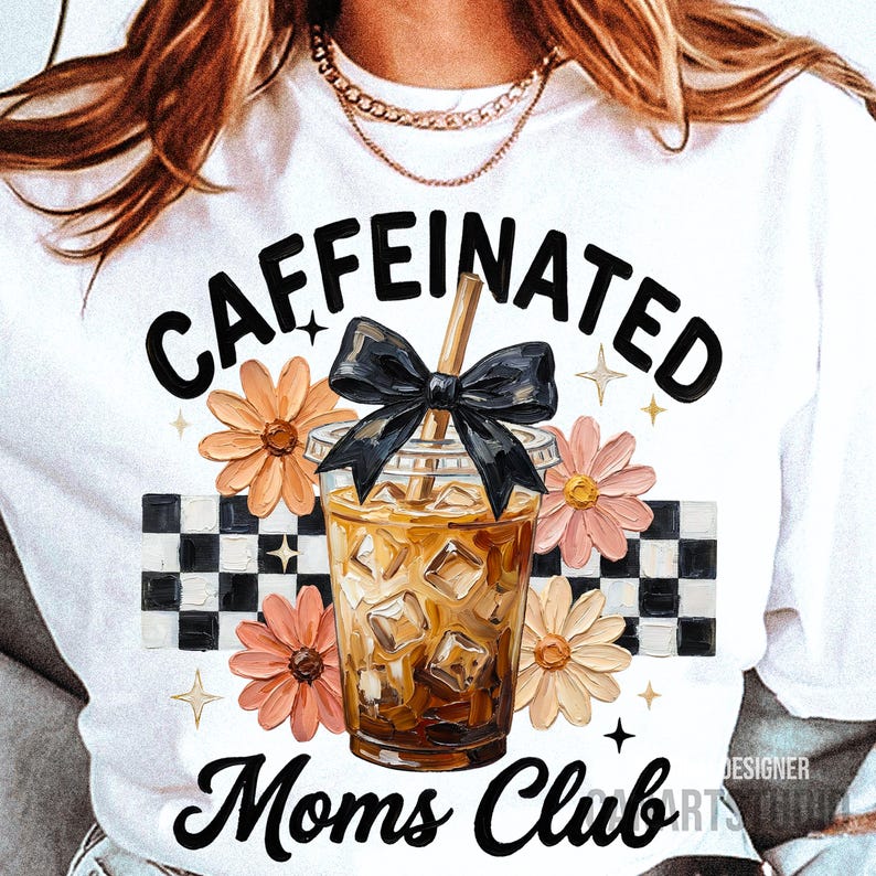 May include: White t-shirt featuring a graphic of an iced coffee with a black bow, surrounded by flowers and a checkered pattern. The text reads "CAFFEINATED Moms Club."
