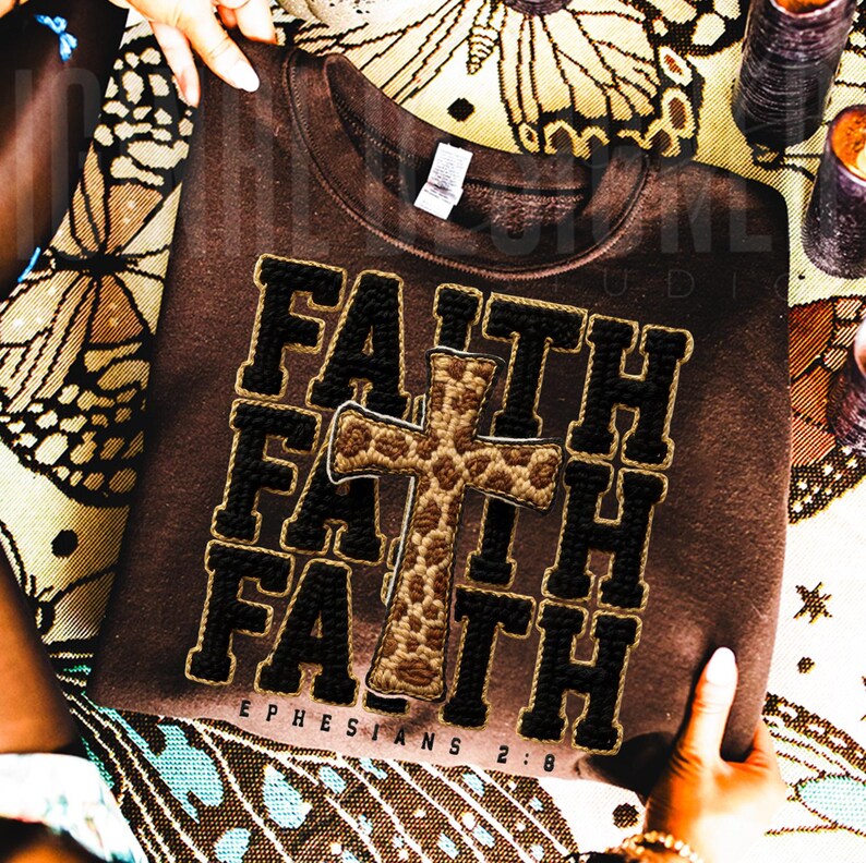 May include: A brown sweatshirt with the word "FAITH" in a stacked design, with a cross in the center. The text "EPHESIANS 2:8" is below the word "FAITH". The letters and cross are in black and tan.