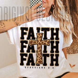 May include: White t-shirt with the word "FAITH" in black block letters, repeated three times, with a cross in the center. The cross has a leopard print design. The text "EPHESIANS 2:8" is printed at the bottom.