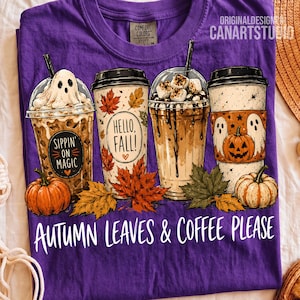 May include: A purple t-shirt featuring a graphic of four coffee cups with autumn themes, including a ghost, maple leaves, and pumpkins. The text reads Sippin on Magic, Hello, Fall!, and Autumn Leaves & Coffee Please. The shirt has a Comfort Colors label.