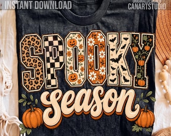 May include: A dark gray t-shirt featuring the text SPOOKY SEASON. The letters in SPOOKY are filled with patterns including leopard print, black and white checkers, orange pumpkins, white daisies, black bats, and vines. Two orange pumpkins sit below.