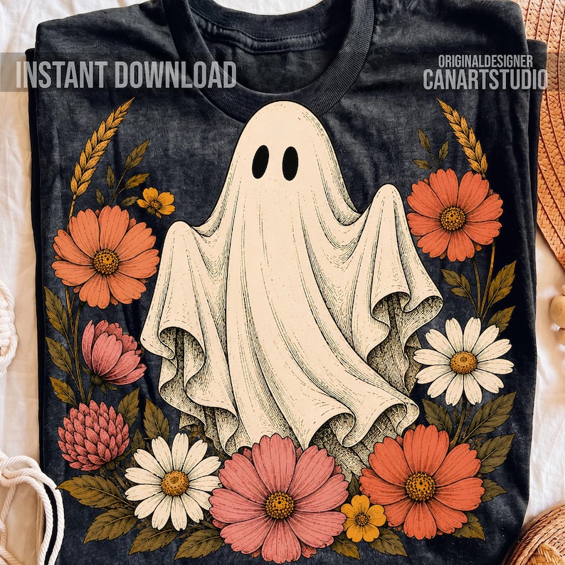May include: A dark charcoal gray t-shirt featuring a central graphic of a white ghost surrounded by a wreath of orange, pink, and white flowers with green leaves. The text "INSTANT DOWNLOAD" and "ORIGINALDESIGNER CANARTSTUDIO" is printed on the shirt.