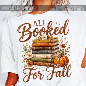 May include: White t-shirt with a fall-themed graphic. The design features a stack of books, a pumpkin, and floral accents. The text reads "All Booked For Fall" in a brown script font. "Instant Download" is at the top left.