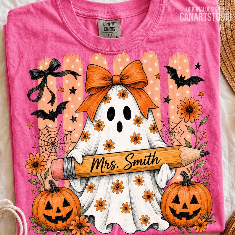 Puede incluir: Una camiseta rosa brillante con una ilustraci&oacute;n de un fantasma blanco con un lazo naranja, sosteniendo un l&aacute;piz amarillo grande con el texto Mrs. Smith. El dise&ntilde;o incluye calabazas naranjas, murci&eacute;lagos negros, telara&ntilde;as y flores naranjas.