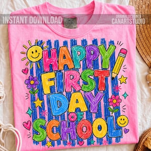 May include: A bright pink t-shirt featuring a colourful graphic with the text HAPPY FIRST DAY OF SCHOOL in a crayon-like style. The design includes a yellow sun, a pencil, flowers, stars, and hearts over a blue vertical striped background.