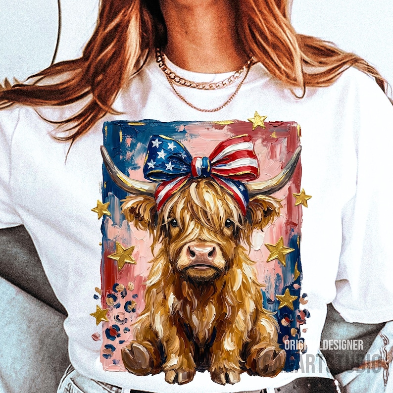 Peut inclure: T-shirt blanc avec une illustration de vache des Highlands. La vache porte un n&oelig;ud patriotique, sur fond de coups de pinceau rouges, blancs et bleus avec des &eacute;toiles dor&eacute;es. Le design comprend le texte "ORIGINAL DESIGNER ART BLACK".