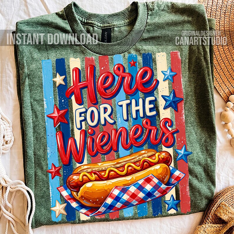 May include: Green t-shirt with a graphic design featuring the text "Here for the Wieners" in red and white, along with a hot dog illustration. The design includes red, white, and blue stripes and stars.