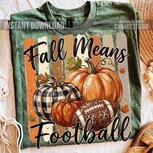 May include: Green t-shirt with a fall-themed graphic. The design features pumpkins, a football, and the text "Fall Means Football" in black script. The shirt has a vintage, distressed look.