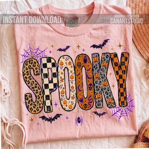 May include: A light pink t-shirt with the word "SPOOKY" in a Halloween-themed design. The letters feature leopard print, checkerboard, floral, and pumpkin patterns. Bats, spiderwebs, and stars surround the word. The shirt has the text "INSTANT DOWNLOAD" and "ORIGINALDESIGNER CANARTSTUDIO".