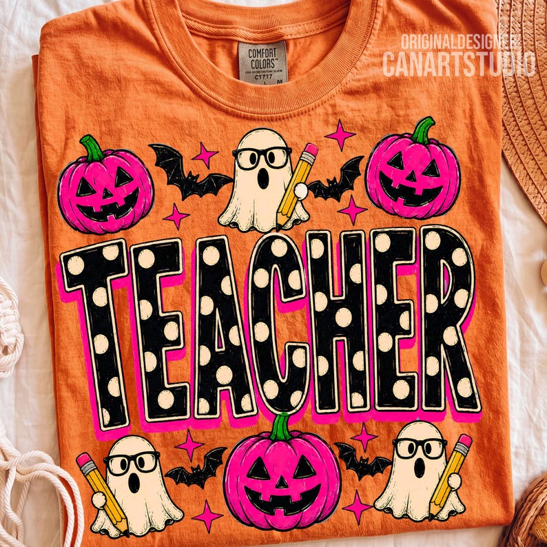 May include: An orange t-shirt featuring a graphic print with the word TEACHER in large black letters with white polka dots. The design includes three white ghosts wearing glasses and holding yellow pencils, three pink jack-o'-lanterns, and bats.