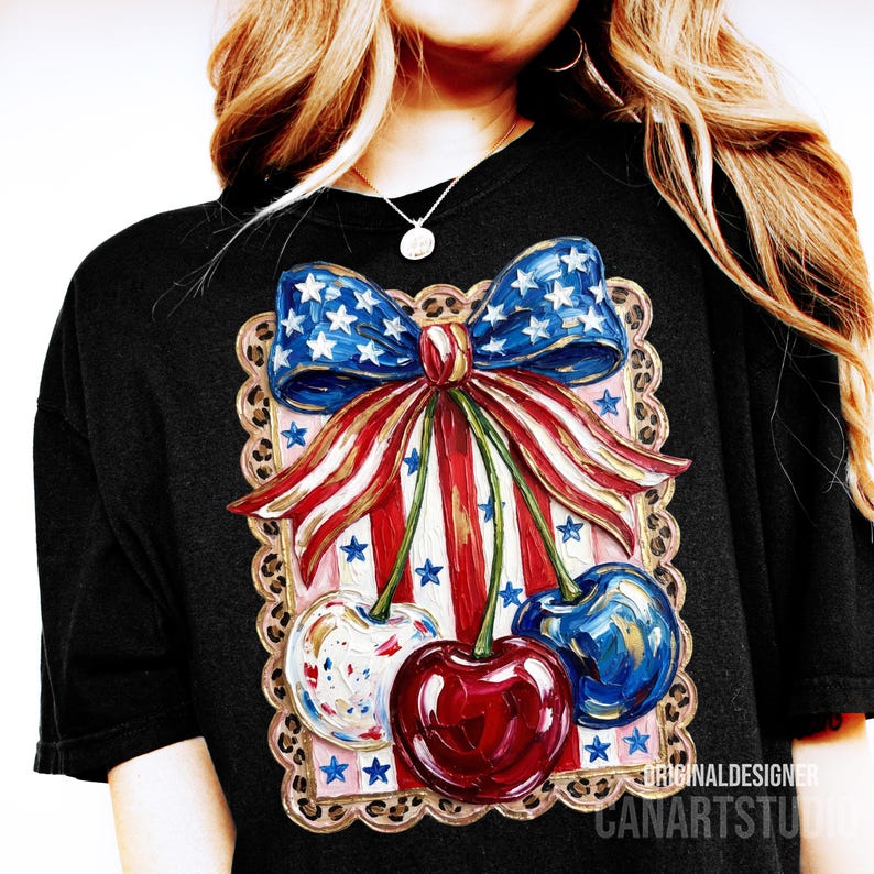 May include: Black t-shirt featuring a patriotic design with a bow and cherries. The bow is blue with white stars, and the cherries are red, white, and blue. The design is framed with a decorative border.