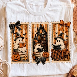 Op de afbeelding: Een wit t-shirt met drie rechthoekige illustraties in postzegelstijl. De ontwerpen tonen geesten met heksenhoeden die boeken lezen en bij pompoenen, een spookhuis en een comfortabele stoel zitten, geaccentueerd met zwarte en oranje strikken.