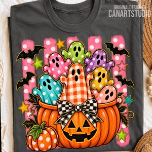 May include: A dark gray t-shirt featuring a large orange jack-o'-lantern with a black and white checkered bow. Inside the pumpkin are colorful ghosts in pink, green, purple, yellow, and blue, surrounded by black bats and yellow stars.