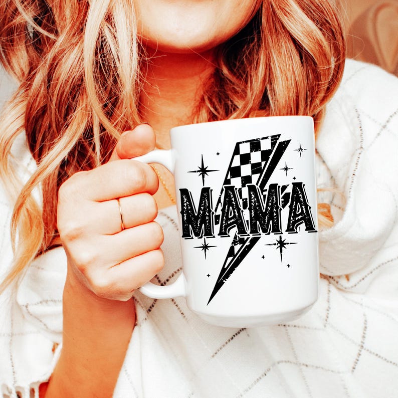 May include: White ceramic mug with a black and white checkered flag design and the word "MAMA" in a bold, black font. The flag is on a lightning bolt shape with stars around it.