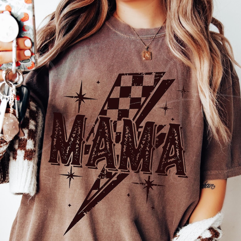 The Word "Mama" In Bold Distressed Font, Overlaid With A Checkered Lightning Bolt And Star Accents. A Trendy Black-And-White Design Perfect For Mom-Themed Creations.