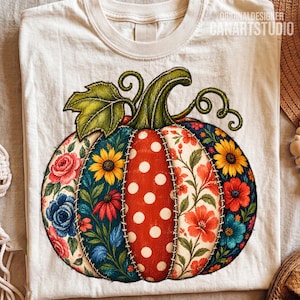 Puede incluir: Una camiseta de color crema con un gran gráfico central de una calabaza. La calabaza está compuesta por segmentos estilo patchwork con patrones florales, girasoles y una sección central roja con lunares blancos, todo delineado con costuras falsas.