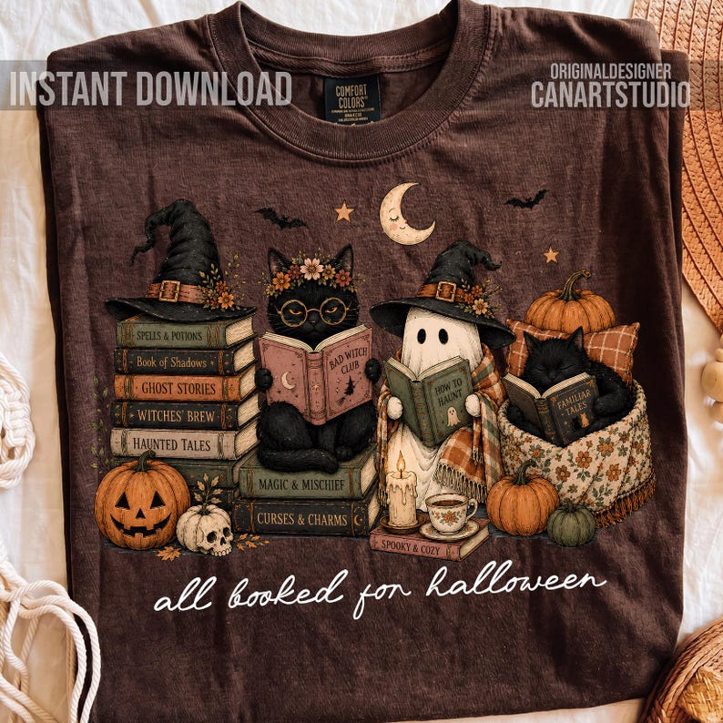 May include: A brown t-shirt featuring a graphic of a black cat wearing glasses and a witch hat reading a book, a ghost in a witch hat reading, and a black cat reading in a basket. Includes pumpkins, a skull, and the text all booked for halloween.
