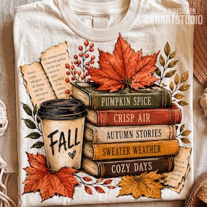 May include: A cream-colored t-shirt featuring a graphic of a coffee cup labeled FALL with a heart, a stack of books titled PUMPKIN SPICE, CRISP AIR, AUTUMN STORIES, SWEATER WEATHER, and COZY DAYS, surrounded by orange maple leaves and berries.