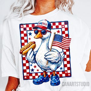 May include: White t-shirt featuring a patriotic goose wearing sunglasses, a baseball cap with "AMERICA" on it, and blue clogs. The goose holds a hot dog and an American flag. The design includes a red, white, and blue checkered border with stars.