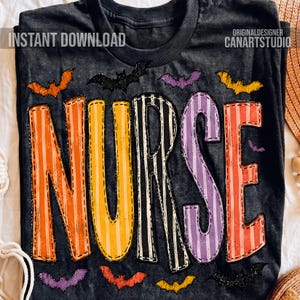 May include: A dark gray t-shirt featuring the word NURSE in large, colorful, striped letters. The letters are orange, yellow, black and white, purple, and red. The design is surrounded by small, scattered illustrations of bats in orange, black, and purple.