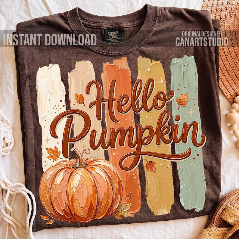 Puede incluir: Camiseta marr&oacute;n con un dise&ntilde;o tem&aacute;tico de oto&ntilde;o. El dise&ntilde;o presenta las palabras "Hello Pumpkin" en una fuente decorativa, una ilustraci&oacute;n de calabaza y pinceladas coloridas. La camiseta tambi&eacute;n tiene el texto "INSTANT DOWNLOAD" y "ORIGINALDESIGNER CANARTSTUDIO".