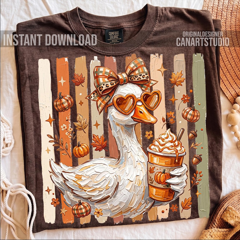 Puede incluir: Camiseta marr&oacute;n con un dise&ntilde;o oto&ntilde;al caprichoso. Un ganso blanco con gafas de sol en forma de coraz&oacute;n y un lazo sostiene un caf&eacute; con leche de calabaza. El dise&ntilde;o incluye calabazas, hojas y el texto "INSTANT DOWNLOAD" y "CANARTSTUDIO".