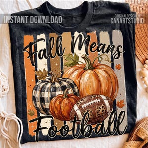 May include: Black t-shirt with a fall-themed graphic. The design features pumpkins, a football with a leopard print, and the text "Fall Means Football" in a decorative font. The background includes vertical stripes in orange, brown, and beige.