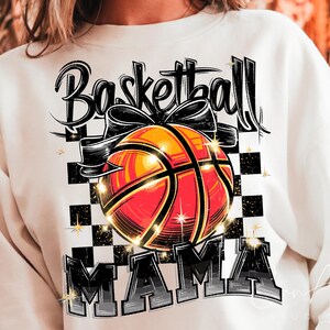 May include: White sweatshirt with a black and orange basketball graphic and the text "Basketball Mama".