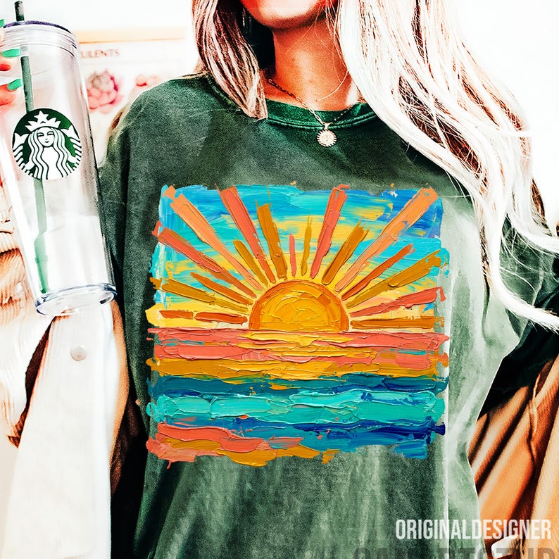 May include: Dark green t-shirt featuring a vibrant, impressionistic painting of a sunset over the ocean. The artwork uses bold brushstrokes and a palette of orange, yellow, blue, and teal. The text "ORIGINALDESIGNER" is printed at the bottom.