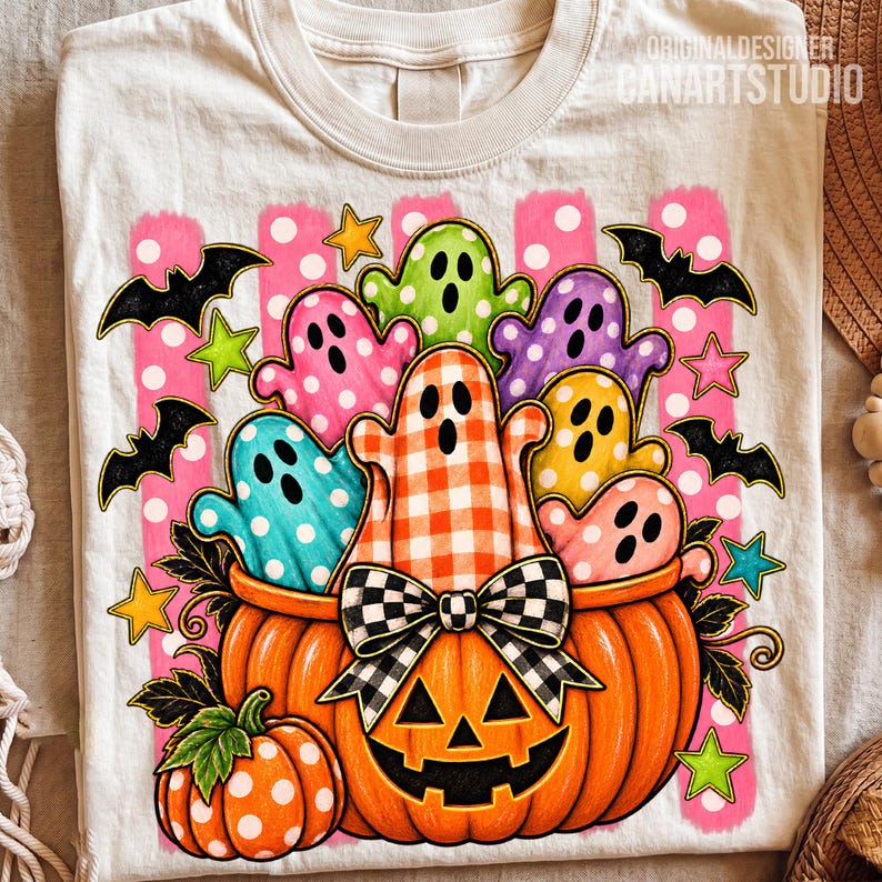 May include: A cream-colored t-shirt featuring a graphic of a large orange jack-o'-lantern filled with colorful ghosts in polka dot and gingham patterns. The design includes black bats, yellow and green stars, and a black and white checkered bow.