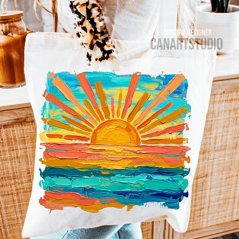 May include: White tote bag featuring a vibrant, textured painting of a sunset over the ocean. The artwork includes a bright yellow sun with orange and yellow rays, and colorful horizontal stripes of blue, orange, and teal. The text "CANARTSTUDIO" is printed on the bag.