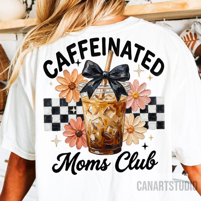 May include: White t-shirt with a graphic of an iced coffee drink, a black bow, and the words "Caffeinated Moms Club." The design includes flowers and a checkered pattern.