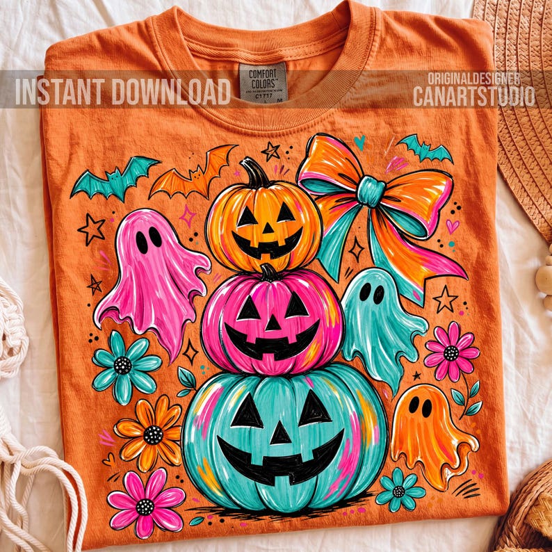 Op de afbeelding: Oranje T-shirt met een Halloween-thema ontwerp. Het ontwerp toont gestapelde pompoenen met uitgesneden gezichten, geesten, vleermuizen en bloemen. De tekst "INSTANT DOWNLOAD" en "CANARTSTUDIO" zijn zichtbaar. Gemaakt door Comfort Colors.